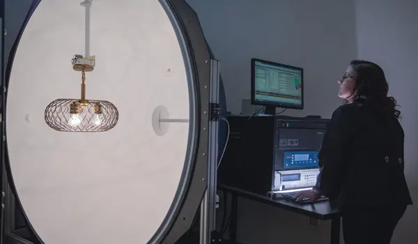 Kichler Peyzaj Aydınlatma'daki bir teknisyen, gelişmiş bir laboratuvar ortamında bir aydınlatma armatürünü test ederken görülüyor