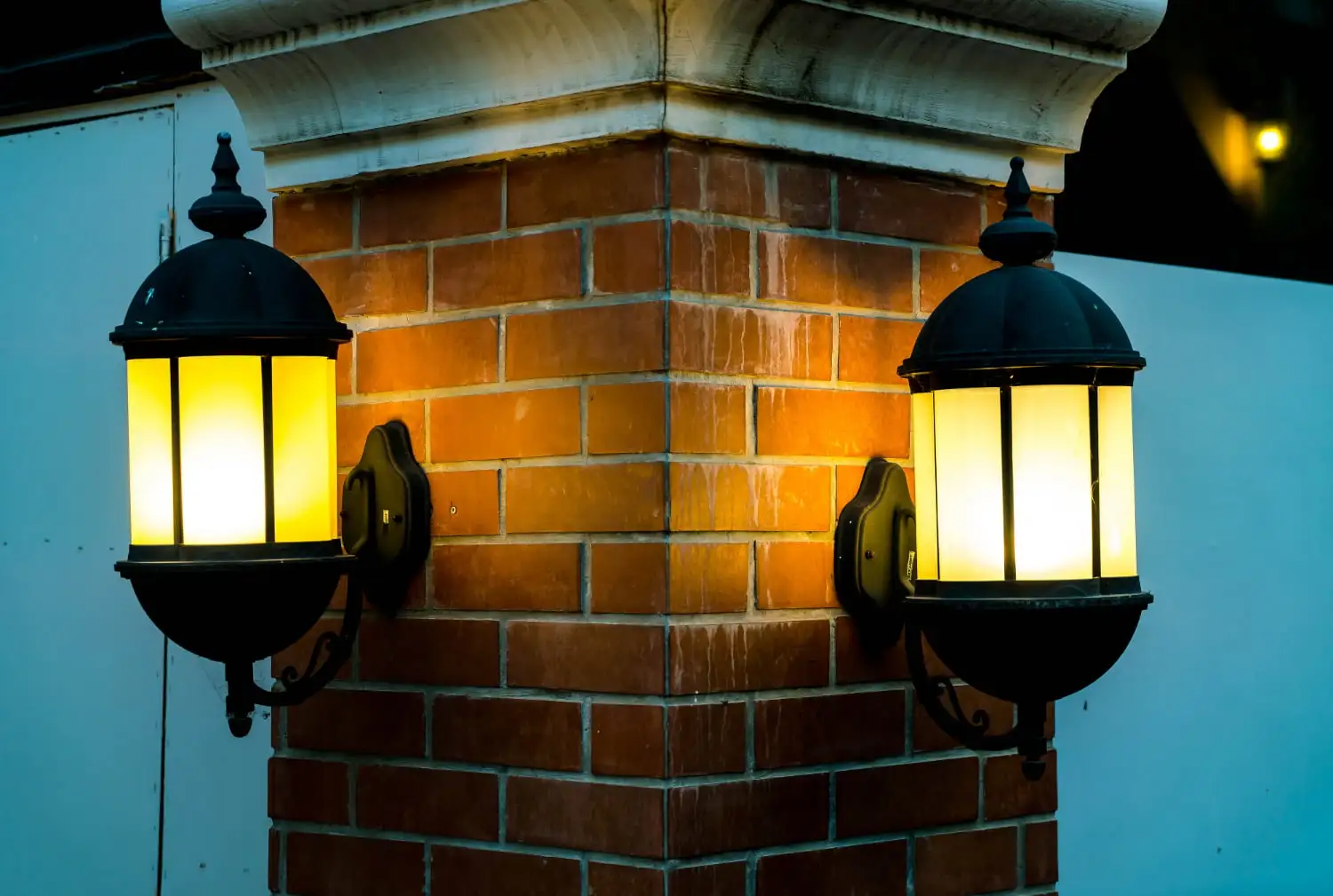 lamp against red brick wall night
