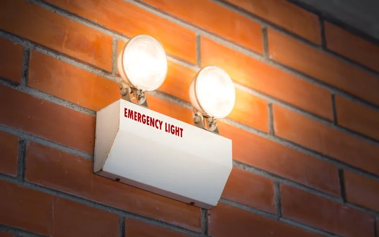 Pared de ladrillo iluminada con dos luces, luz blanca brillante. Imagen incluida en Una guía para el alumbrado de emergencia.