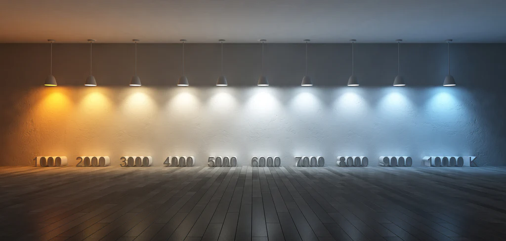 Изображение комнаты с освещением от теплого белого до холодного белого, демонстрирующее шкалу цветовой температуры в Кельвинах от 2000К до 8000К под подвесными светильниками.