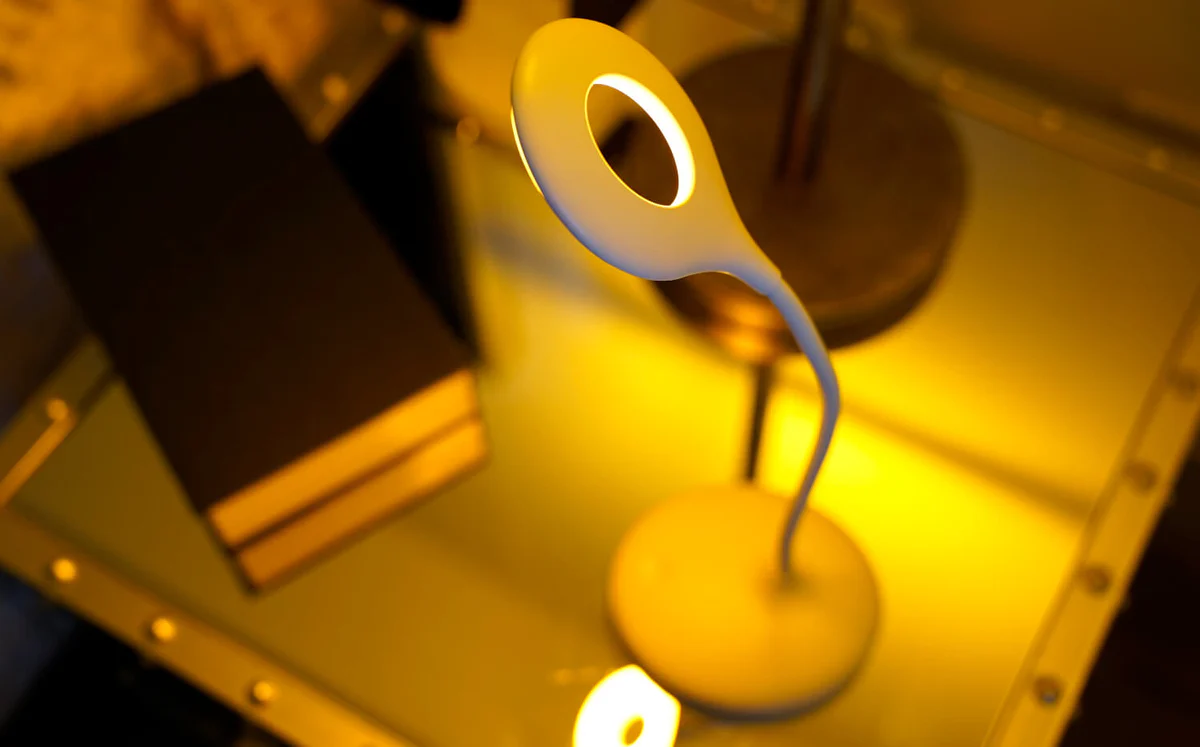 Luz LED amarela quente em uma mesa de estudo proporcionando iluminação ideal para leitura e estudo