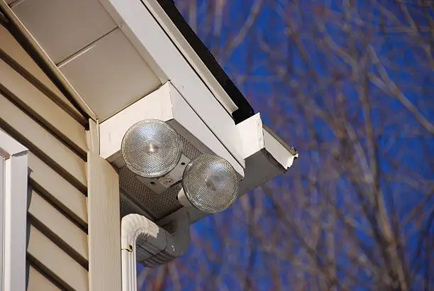 Close up of two floodlights illuminating a house exterior