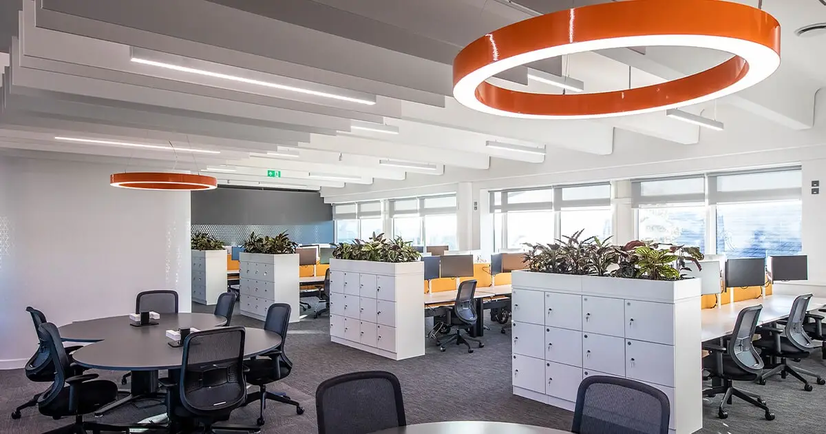 Office with orange lighting and black chairs meeting UK Workplace Lighting Regulations