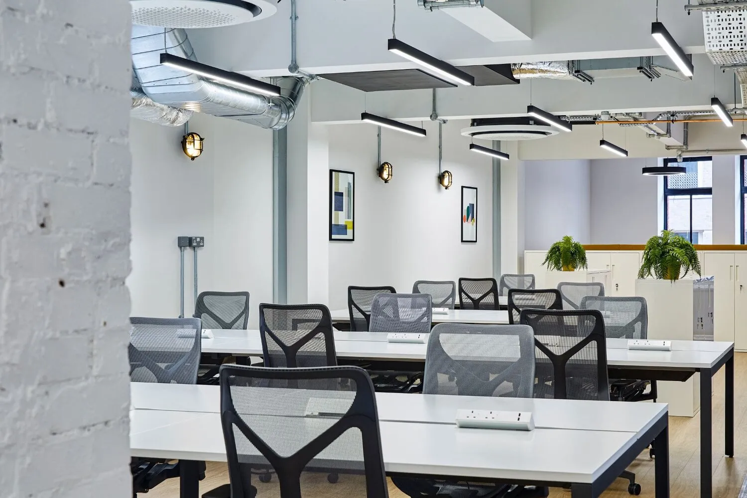 White walled office with black chairs from top office lighting manufacturers worldwide
