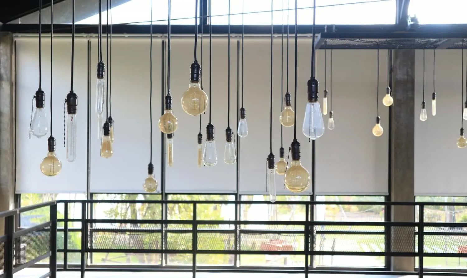 A room with numerous pendant light bulbs hanging from the ceiling